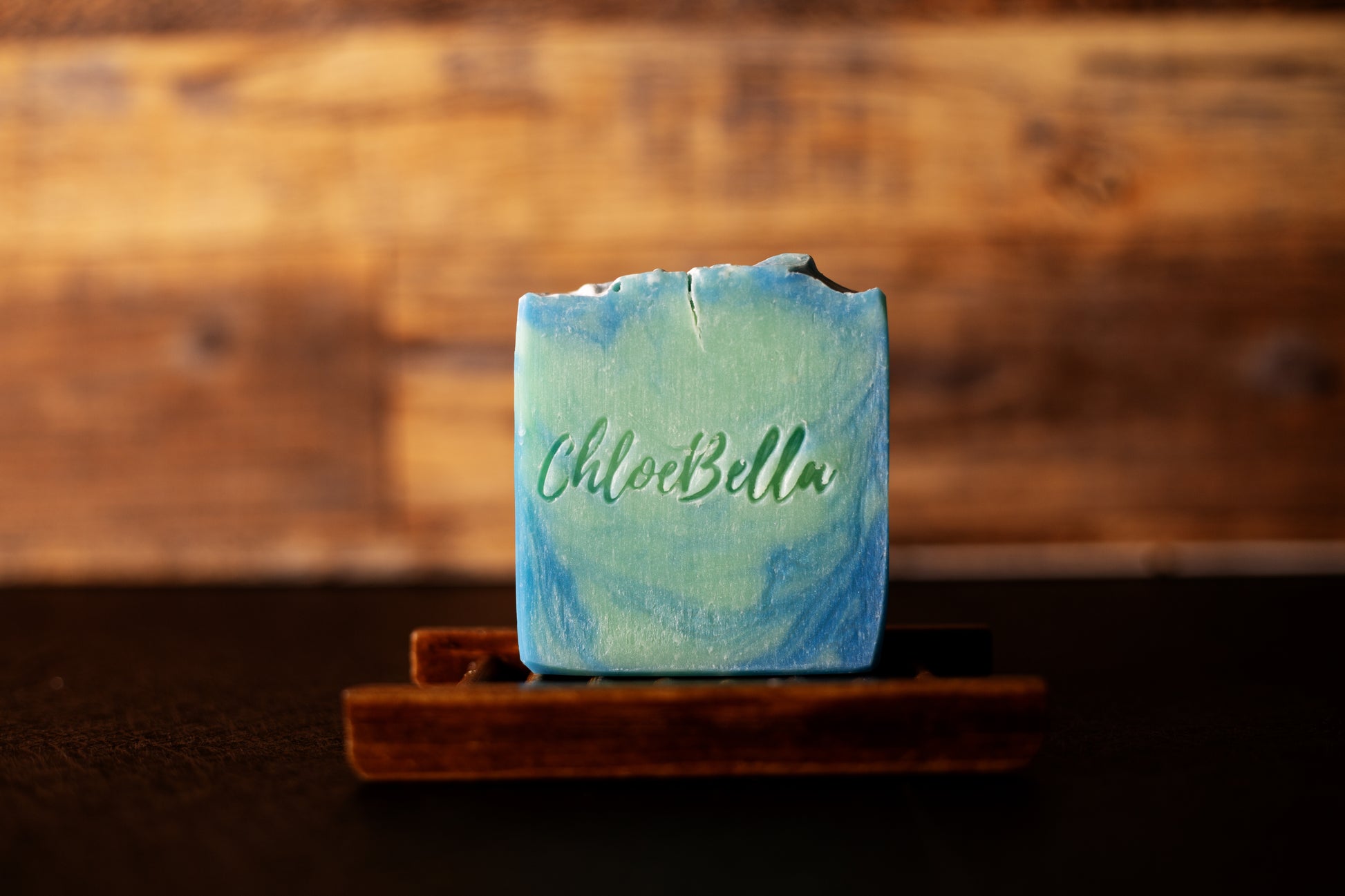 Handcrafted eucalyptus mint soap body bar sitting on a wooden stand