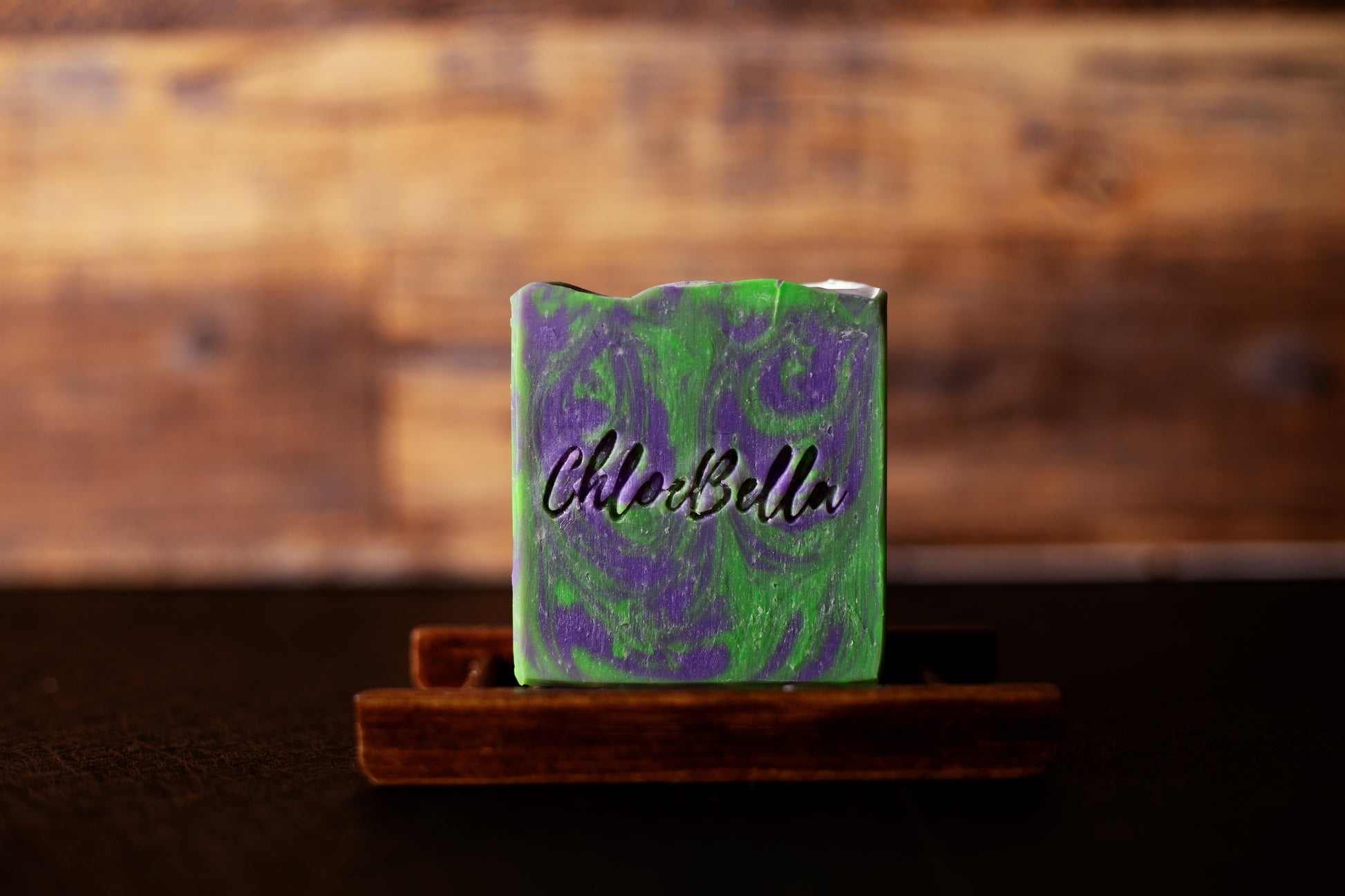 Handcrafted lavender sage soap body bar sitting on a wooden stand