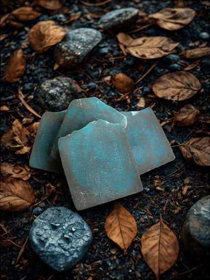 Blue soap bars on a dark surface with leaves